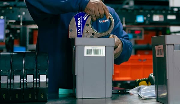 A warehouse worker placing a STEALTH Hydraulic Torque Wrench in a shipping container to be sent to a customer
